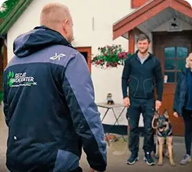 Hundetræner møder familie med hund foran hus