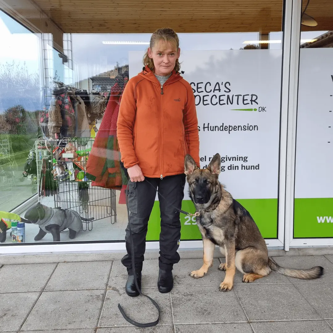 Anette med en schæferhund foran butikken