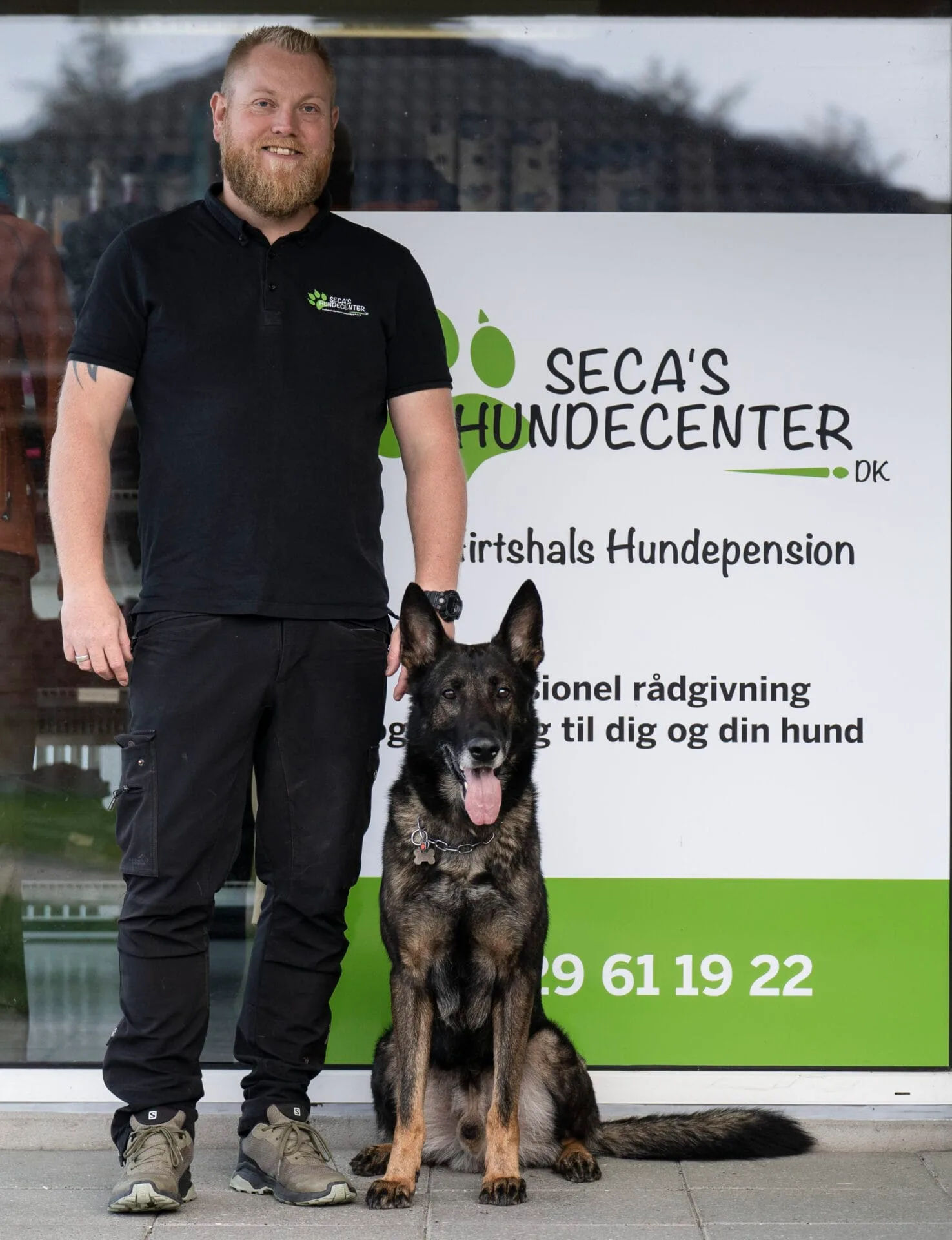Mand og schæferhund foran Seca’s Hundecenter